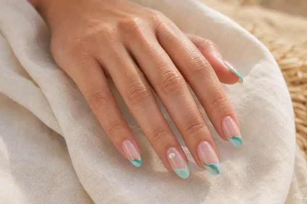 Turquoise wave-tip beach nails with a delicate shell accent