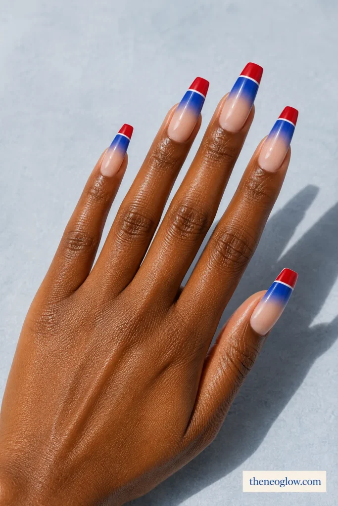 Long soft coffin nails with red and cobalt tip bands fading into sheer centers with thin white lines.