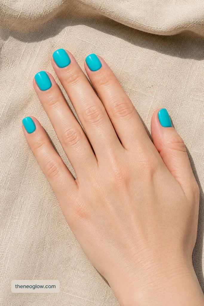 Short squoval turquoise press-on nails with glossy solid color and natural-looking cuticle placement.