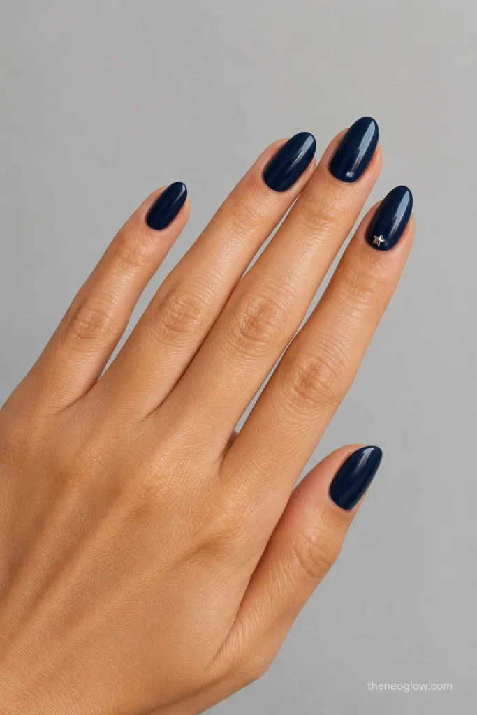 Deep navy almond nails with one miniature silver star accent