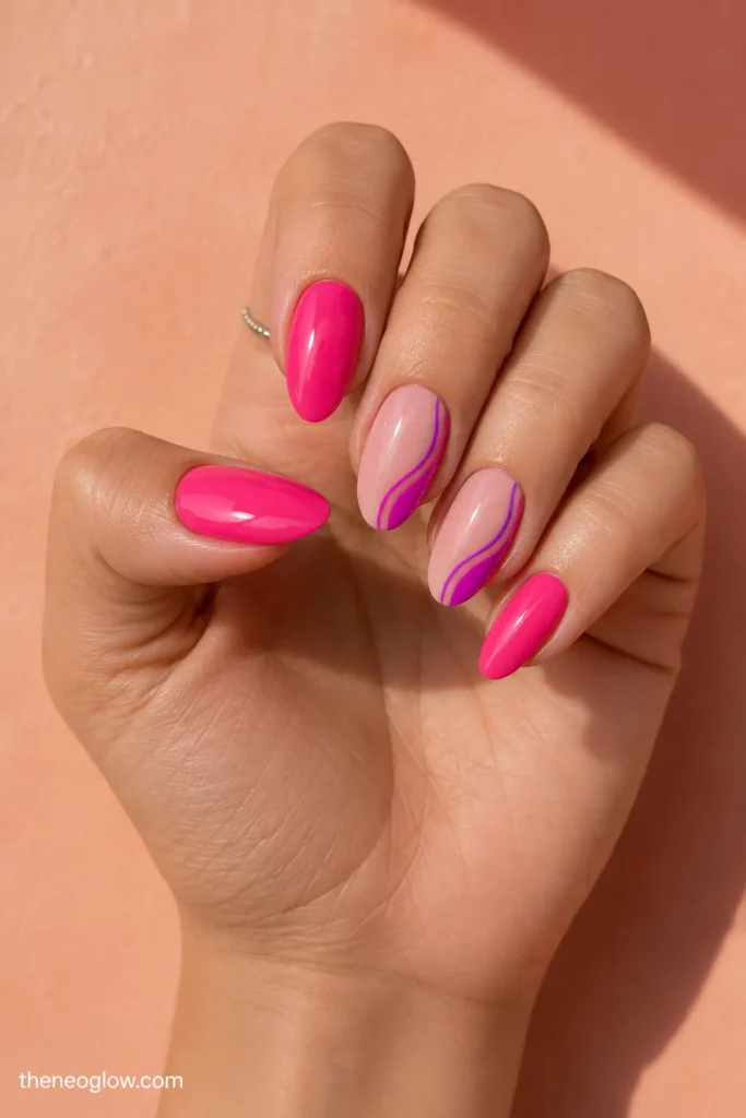 Medium almond nails combining glossy hot pink with controlled fuchsia side swirls over a sheer base.