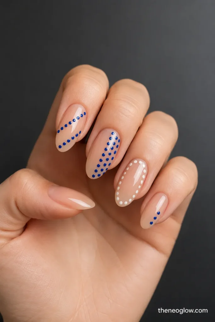 Sheer almond nails with diagonal dotted rows, a half-nail dot field, an open center window, and varied dotted panels.