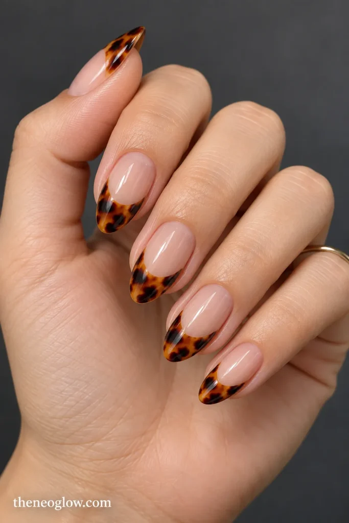 Medium almond nails with deep tortoiseshell French tips over a clean sheer neutral base.