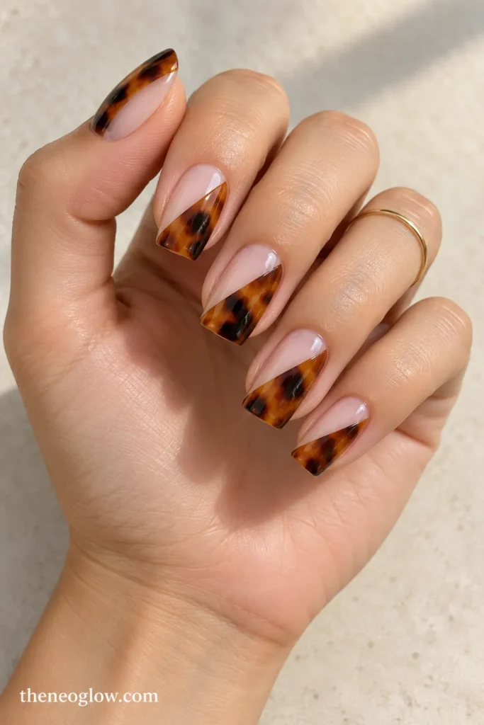 Nails divided diagonally between translucent nude and layered amber tortoiseshell.