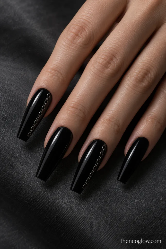 Glossy black coffin nails with a thin gunmetal chain-like line along one sidewall.