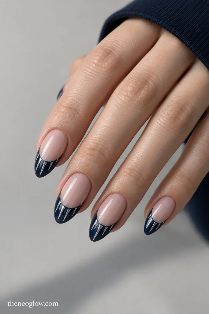 Medium almond nails with midnight-navy French tips and slender silver-white icicle details.
