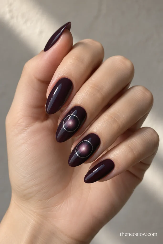 Smoky plum almond nails with a soft eclipse halo and a thin silver ring on accent nails.