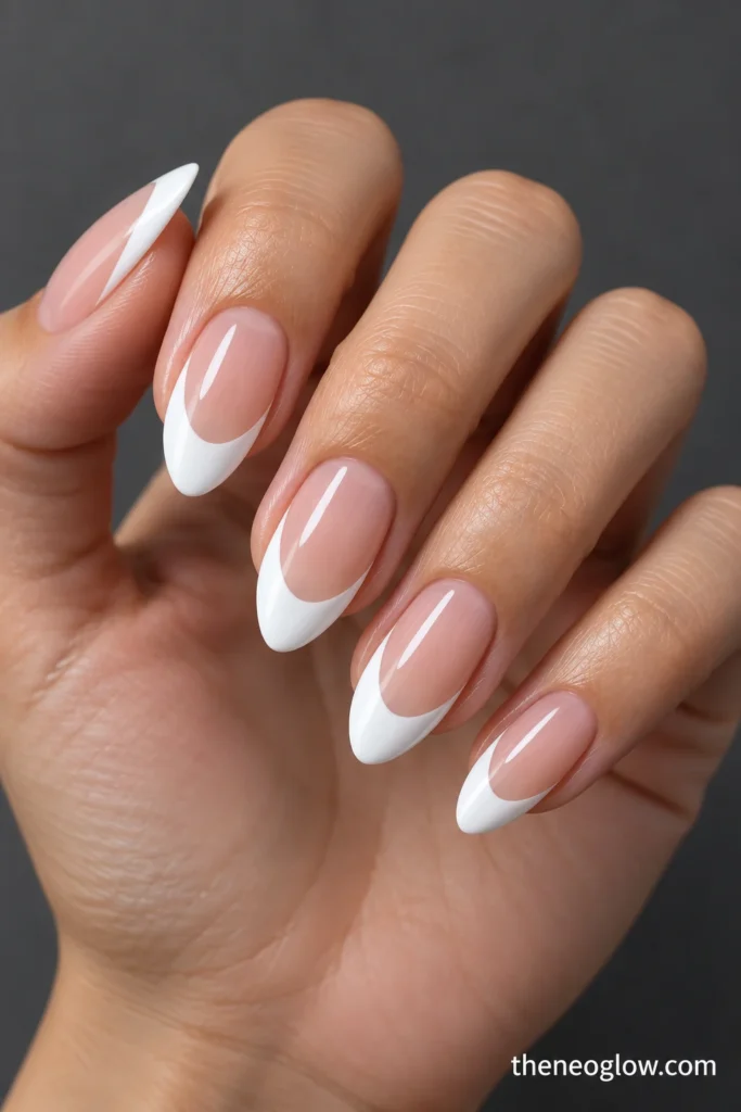 Medium almond nails with deep bright-white U-shaped French tips and translucent warm-rose centers.