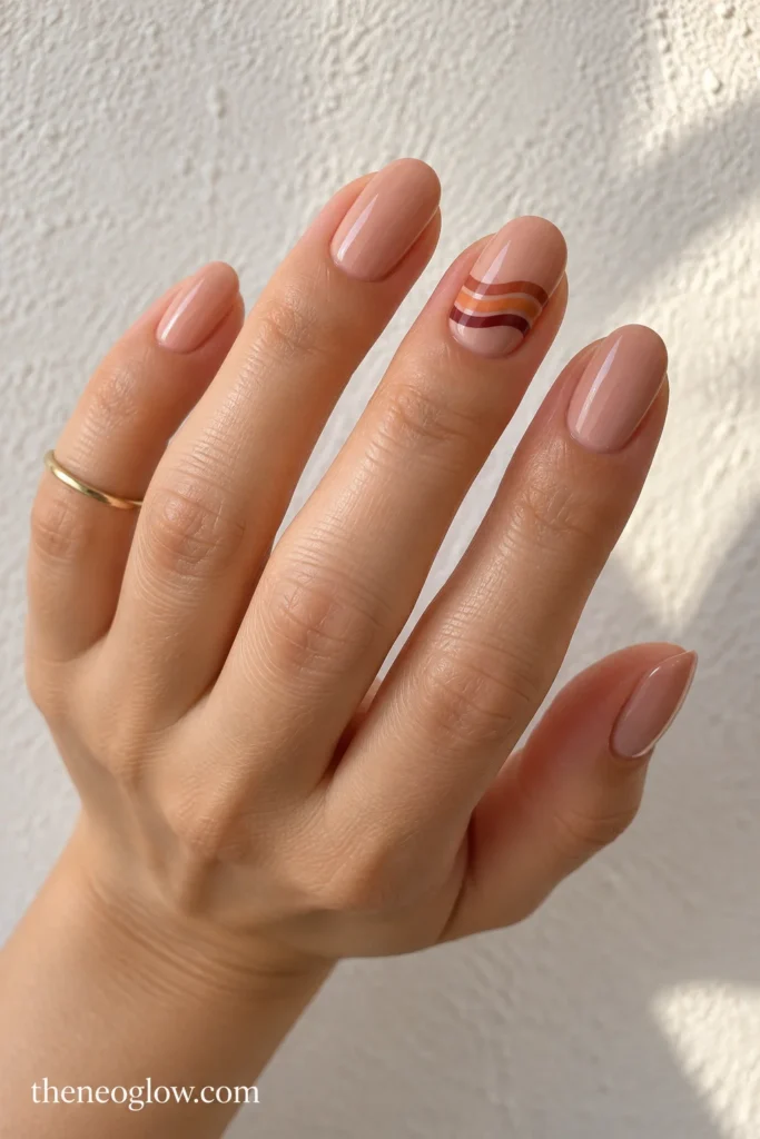 Blush-tan round nails with baked-clay, apricot and wine ripple bands on the ring finger.