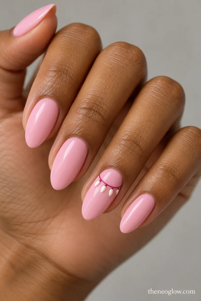 Medium ballet-pink almond nails with a curved raspberry garland and four small ivory bulbs on the ring finger.