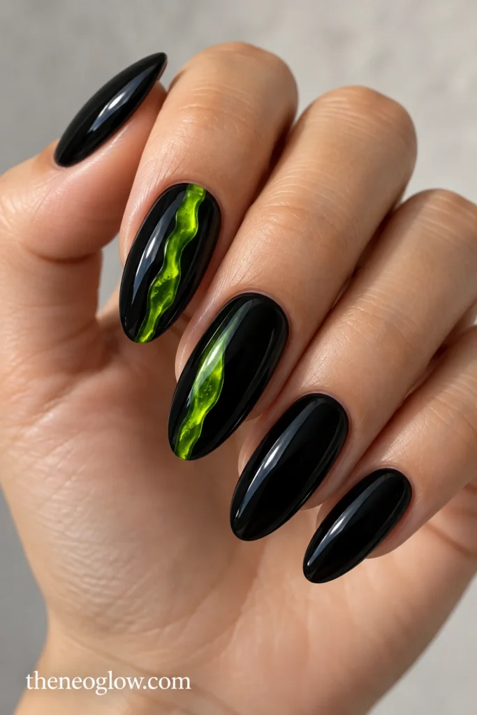Glossy black almond acrylics with a narrow translucent lime-green slime stripe on the middle nail.