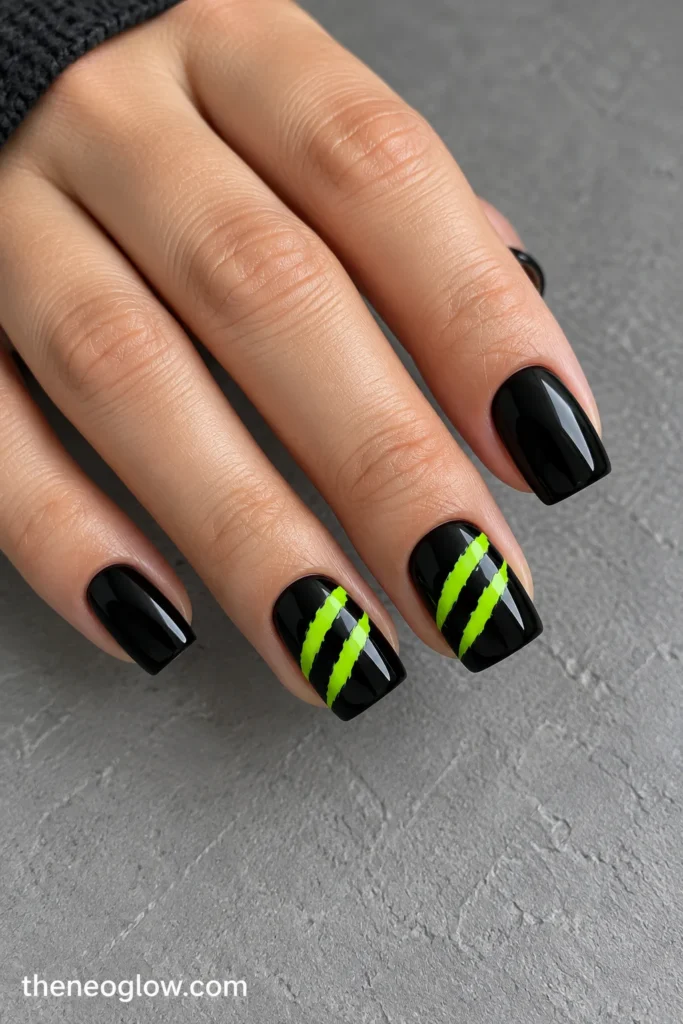 Medium-short black square acrylics with pairs of flat neon-lime diagonal claw marks.