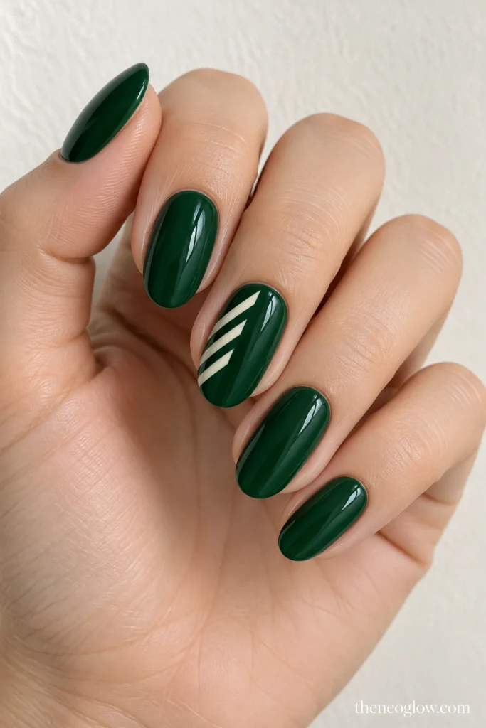 Glossy bottle-green oval nails with three narrow diagonal ivory bars on the middle finger.