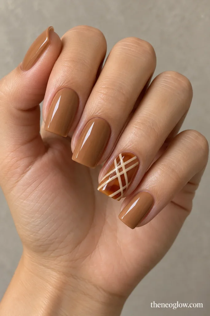 Caramel square nails with one translucent amber accent crossed by thin cream lattice lines.