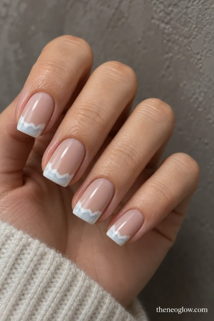 Medium squoval nails with uneven ivory frost French bands and fine pale-blue shadows.