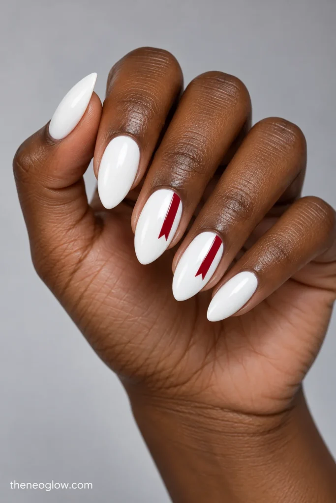 Glossy opaque-white almond nails with narrow cranberry-red ribbon lines ending in V-cut tails on two accent fingers.