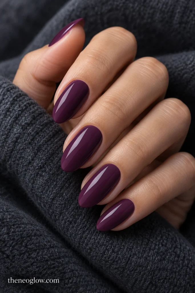 Medium soft-almond nails covered in opaque cool purple-plum cream polish.