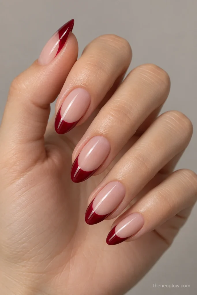 Medium almond nails with deep glossy red French tips and pronounced curved smile lines.