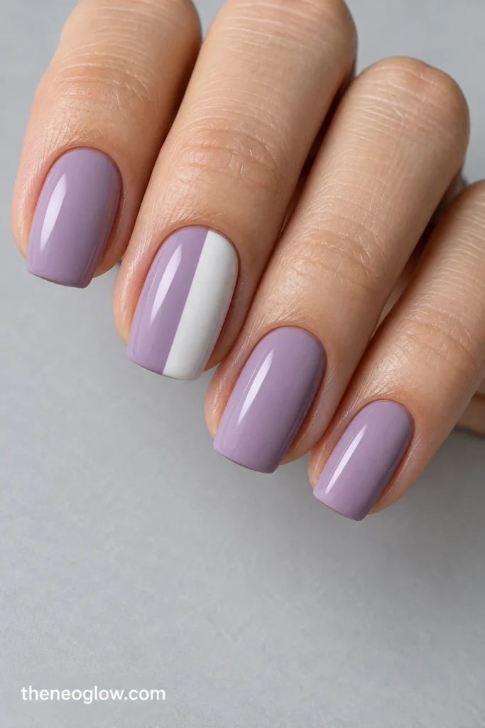 Medium squoval lilac nails with the middle nail divided vertically into lilac and chalk-white halves.