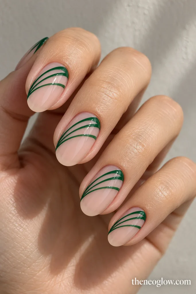 Medium oval nails with three fine forest-green rays spreading from one free-edge corner. fall french tip nails