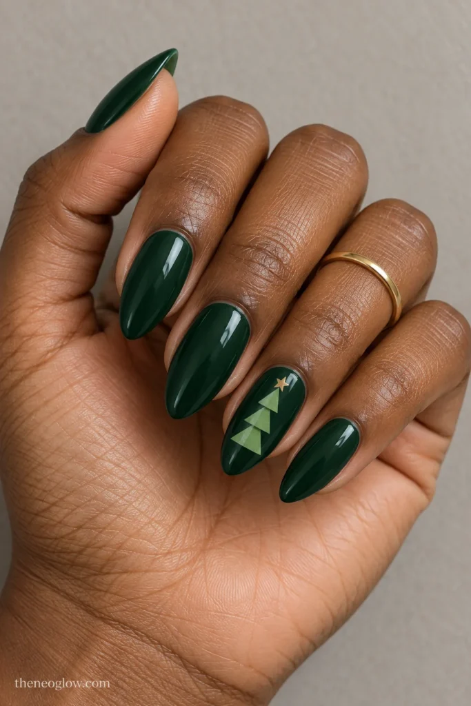 Forest-green almond nails with a three-tier light-fir Christmas tree and tiny gold point on the ring finger.