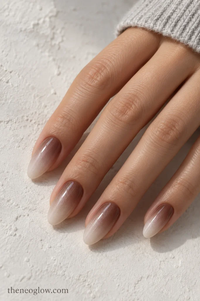 Medium almond nails fading from cocoa at the cuticles to cool milky beige with a pearl sheen. november nails