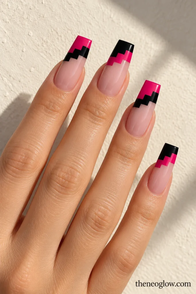 Long coffin acrylics with sheer pink bases and geometric fuchsia-and-black stair-step tips.