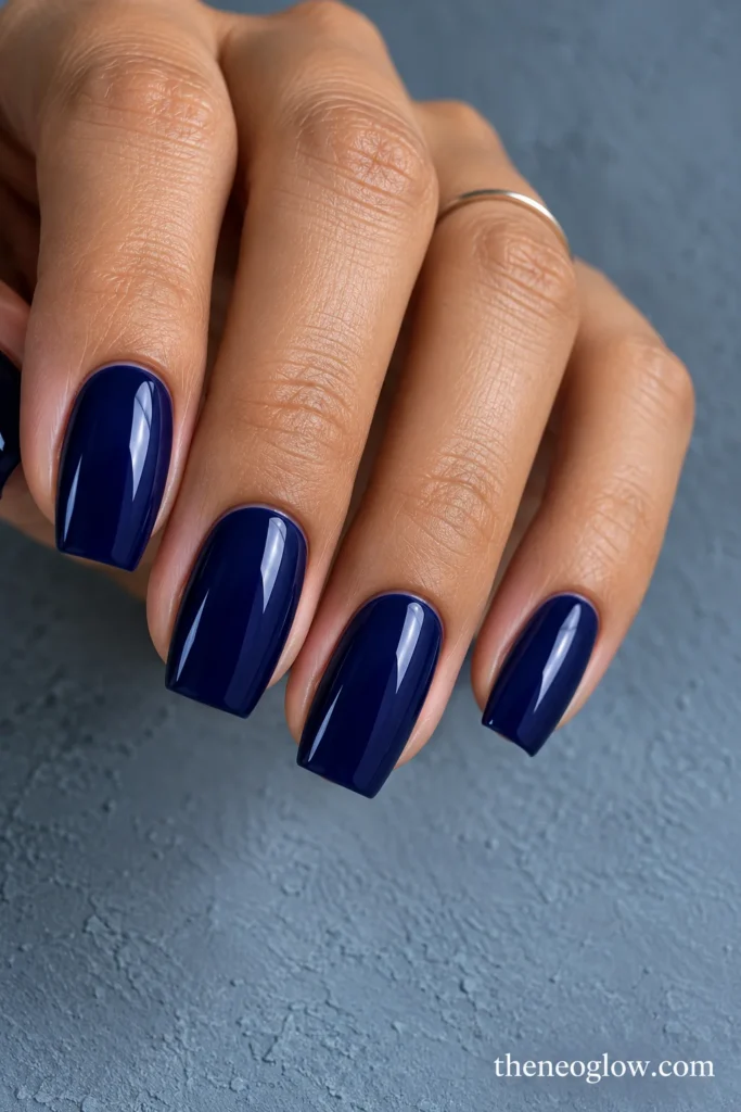 Medium tapered-square nails coated in deep blue-violet indigo polish with high gloss.