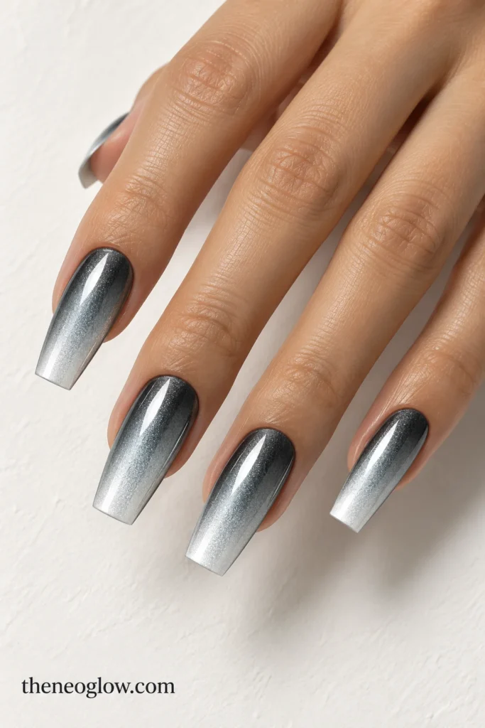 Long tapered-square nails fading from dark gunmetal at the cuticle to icy silver at the tips