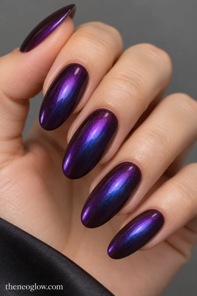 Long oval aubergine nails with a smooth violet-to-blue iridescent glaze.