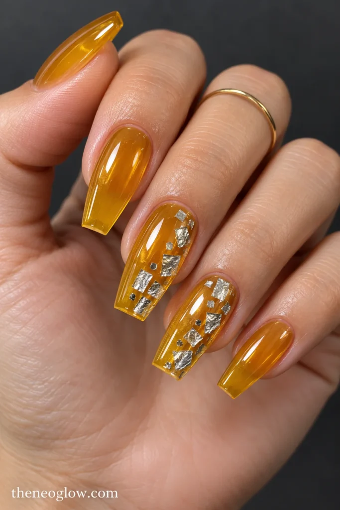 Translucent honey-gold coffin nails with flat silver foil tile clusters on middle and ring fingers.