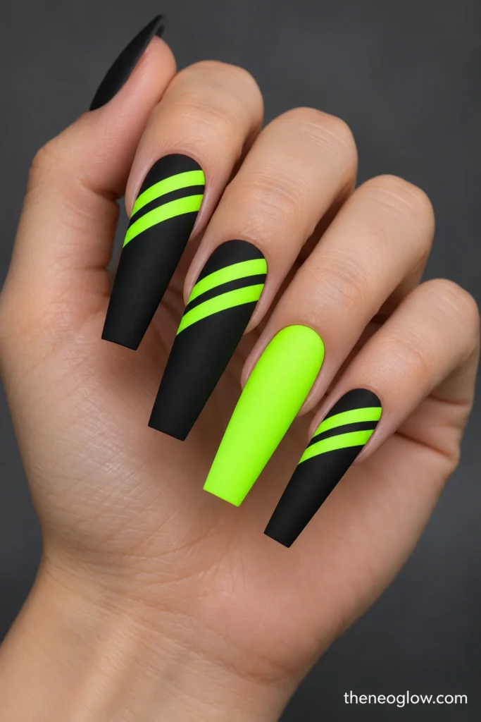 Long matte-black coffin acrylics with two fluorescent-lime diagonal hazard stripes.