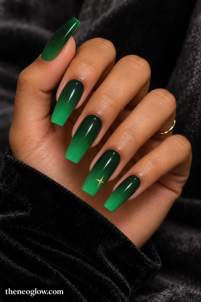 Long glossy coffin nails fading from moss green to emerald with a small champagne-gold star on the ring finger. green christmas nails
