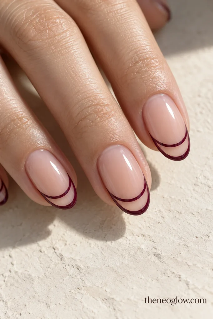 Medium oval nails with fine mulberry outlines surrounding transparent French-tip bands.