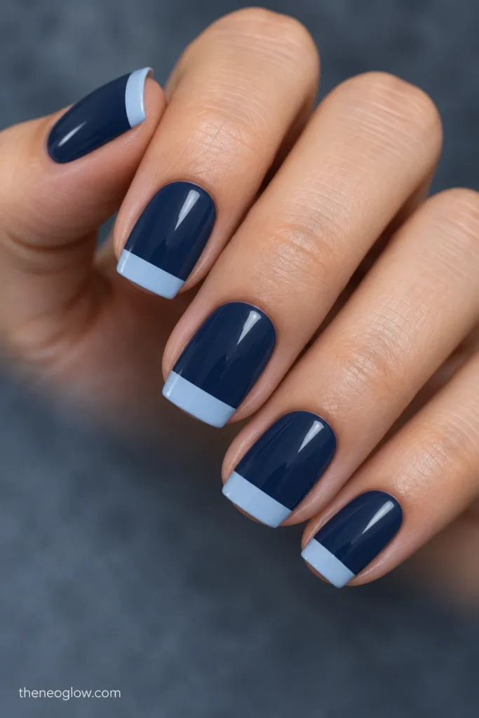 Medium-short soft-square nails with dusty navy bases and flat frost-blue rectangular tip bands.