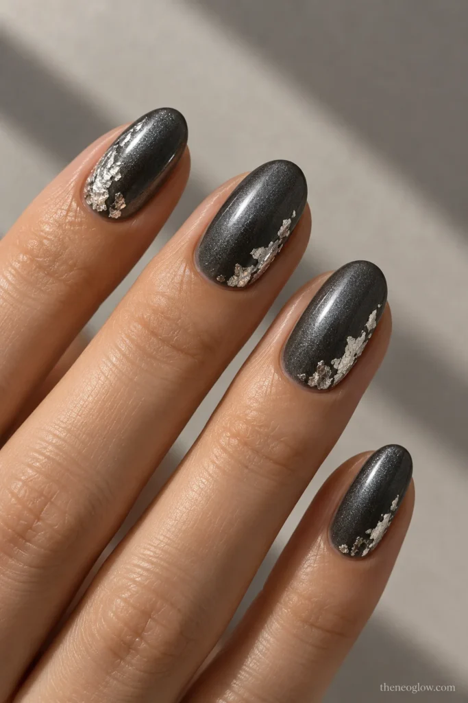 Glossy deep pewter oval nails accented with irregular bright silver foil near one side and lower corner.
