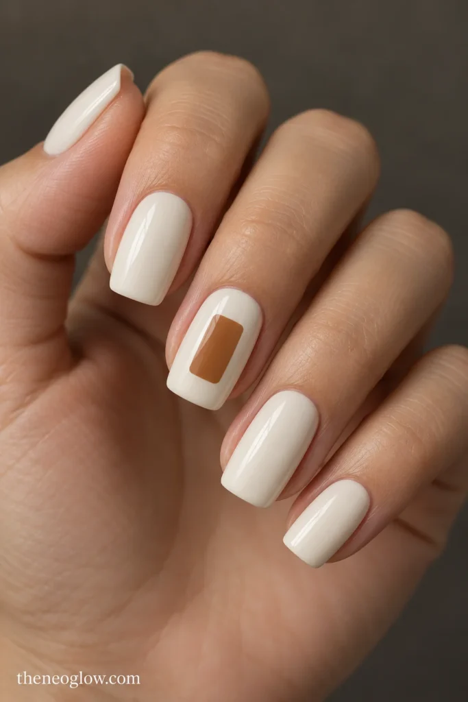 Ivory soft-square nails with a rounded caramel rectangular accent on the middle finger.