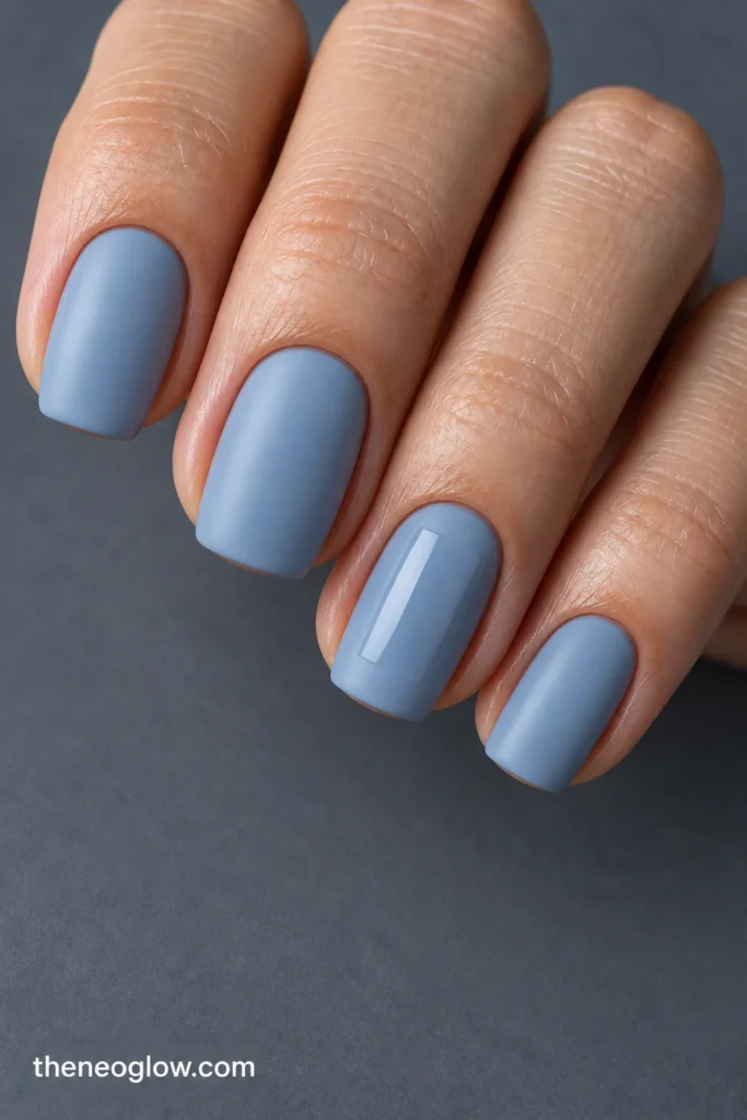 Short rounded-square ice-blue nails with a clear glossy rectangular tile on the satin-matte ring nail.