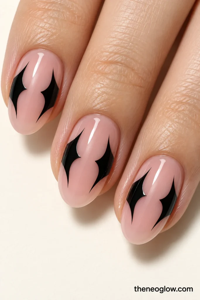 Sheer pink nails with black bat-wing shapes forming clear negative-space center windows.