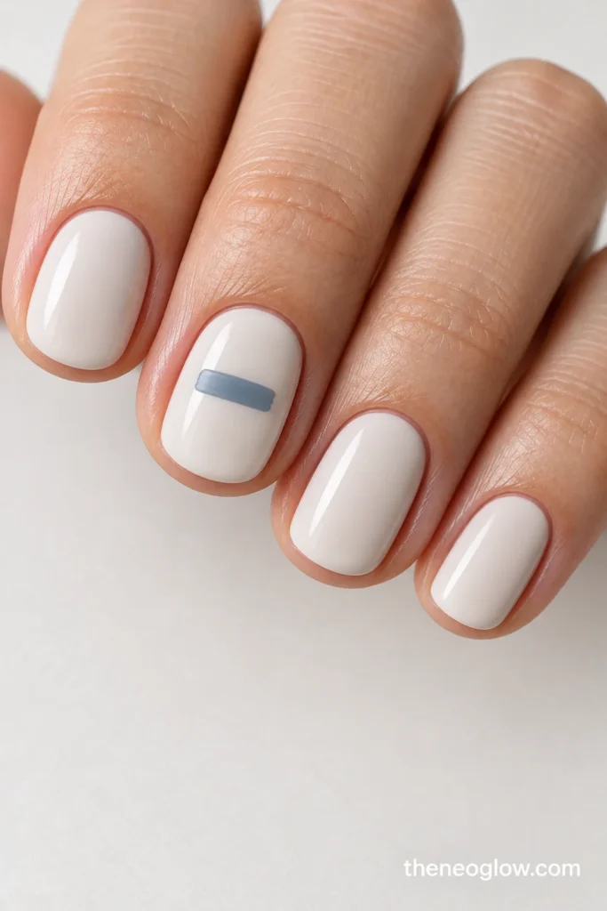 Very short cool-cream round nails with one short fog-blue horizontal dash on the middle nail.